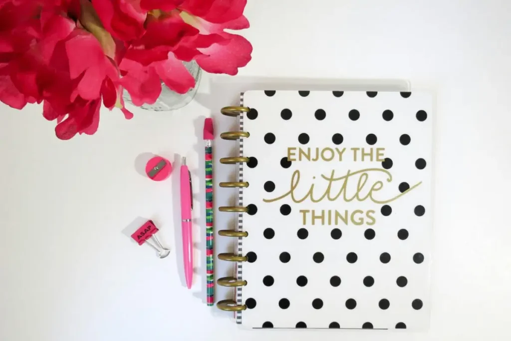notebook with 'enjoy the little things' written on the cover