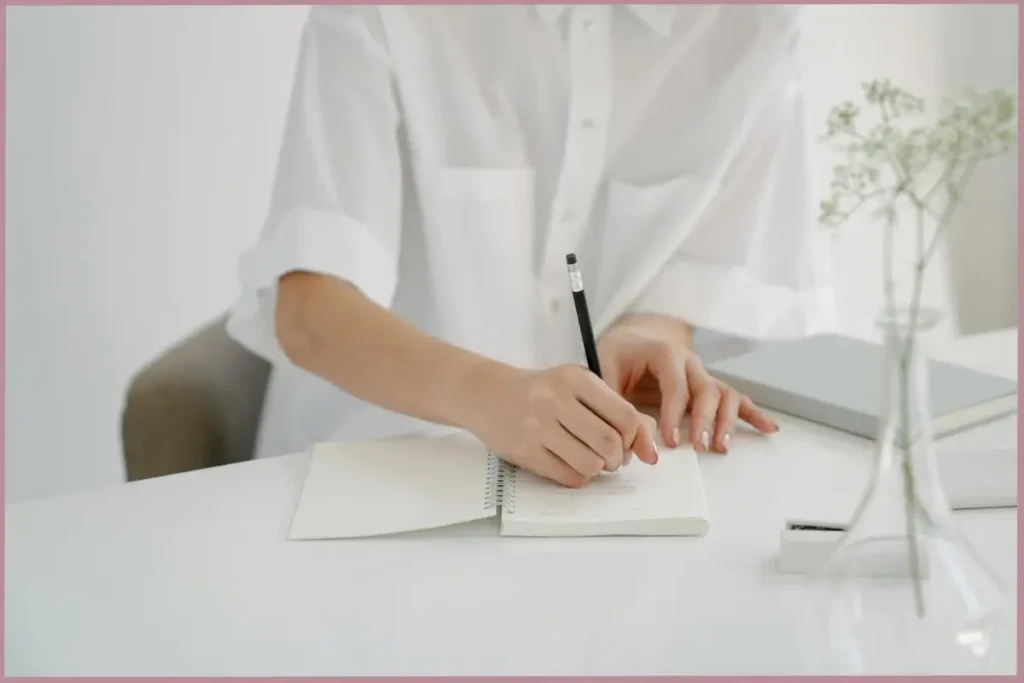 lady writing in her journal reflecting on her journey as an empty nester mom