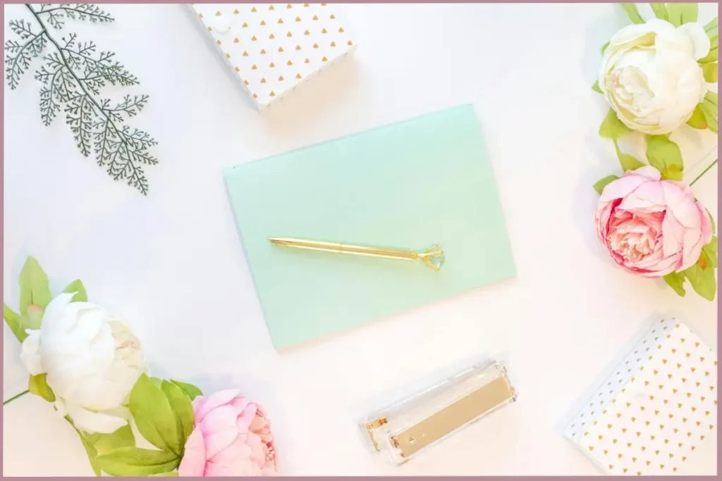 Mint color journal surrounded by pink and white roses - benefits of stream of consciousness writing