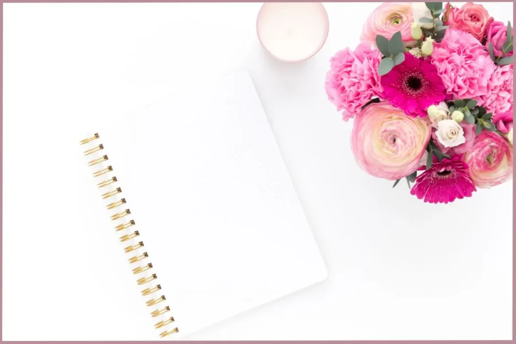 open journal with flower bouquet and candle at the side